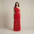 Woman wearing a red one-shoulder gown against a beige background