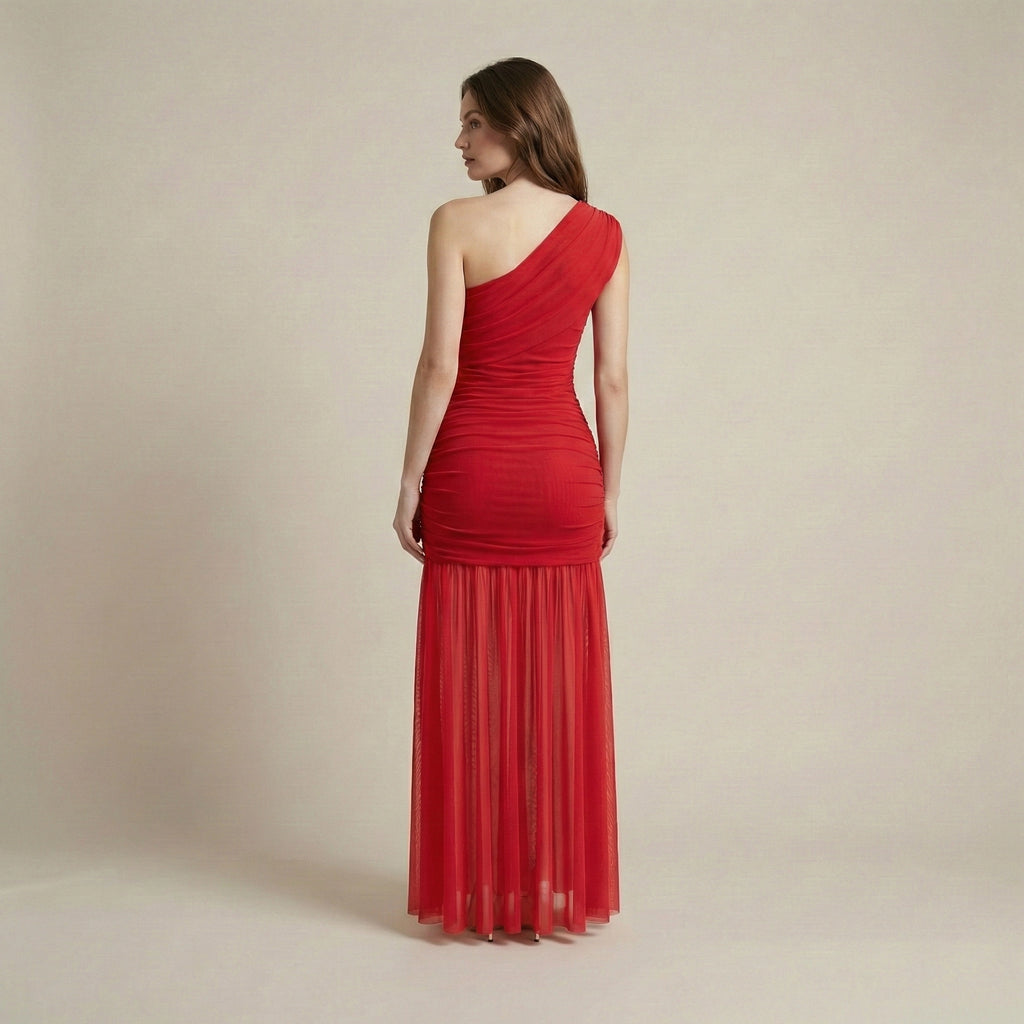 Woman wearing a red one-shoulder dress against a beige background