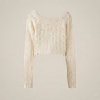 Cream-colored sweater with intricate pattern on a beige background
