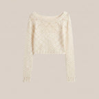 Cream-colored sweater with intricate pattern on a light gray background