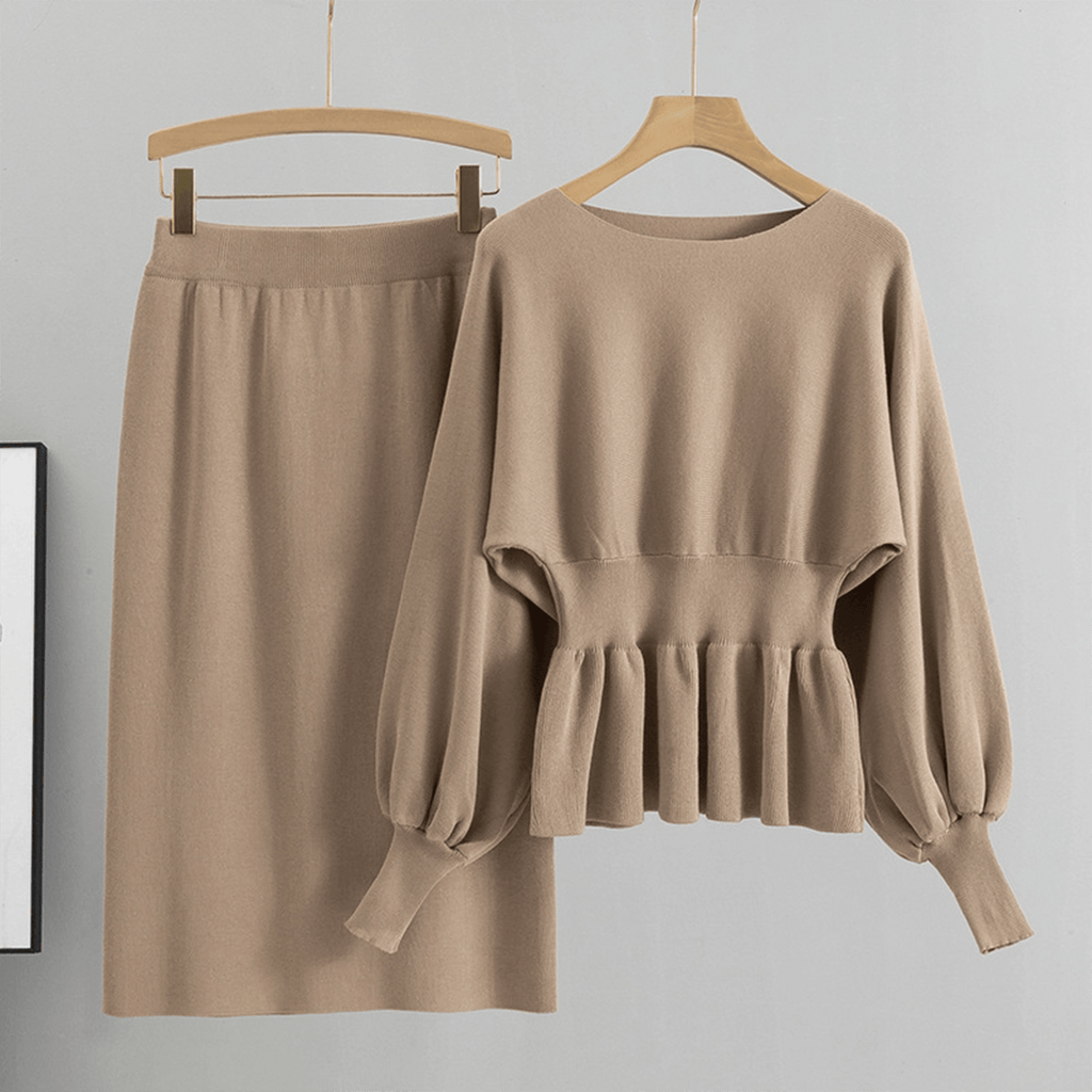 Beige sweater and skirt set on hangers against a gray background
