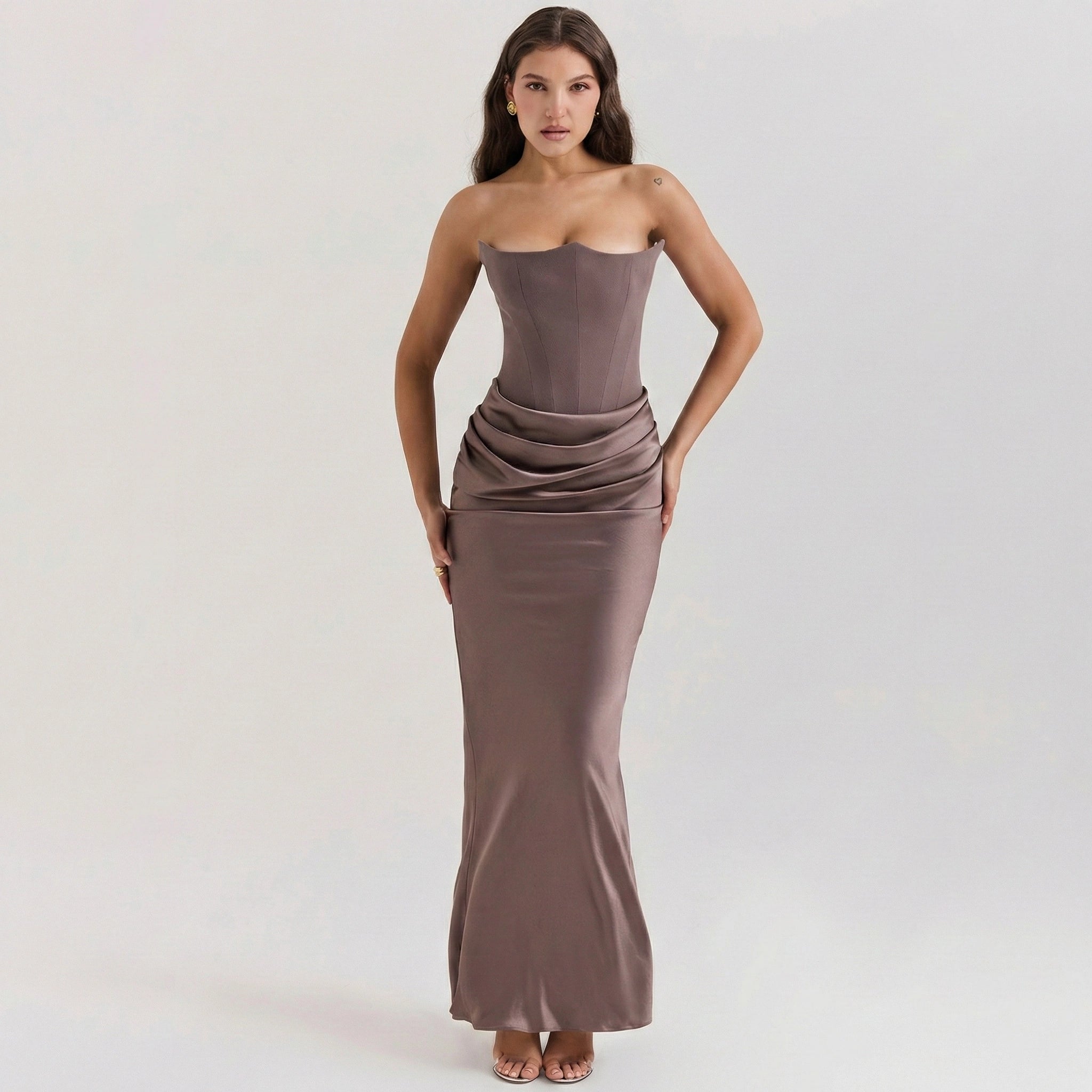 Woman wearing a strapless brown evening gown on a white background