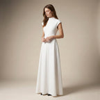 Woman wearing a white dress against a beige background