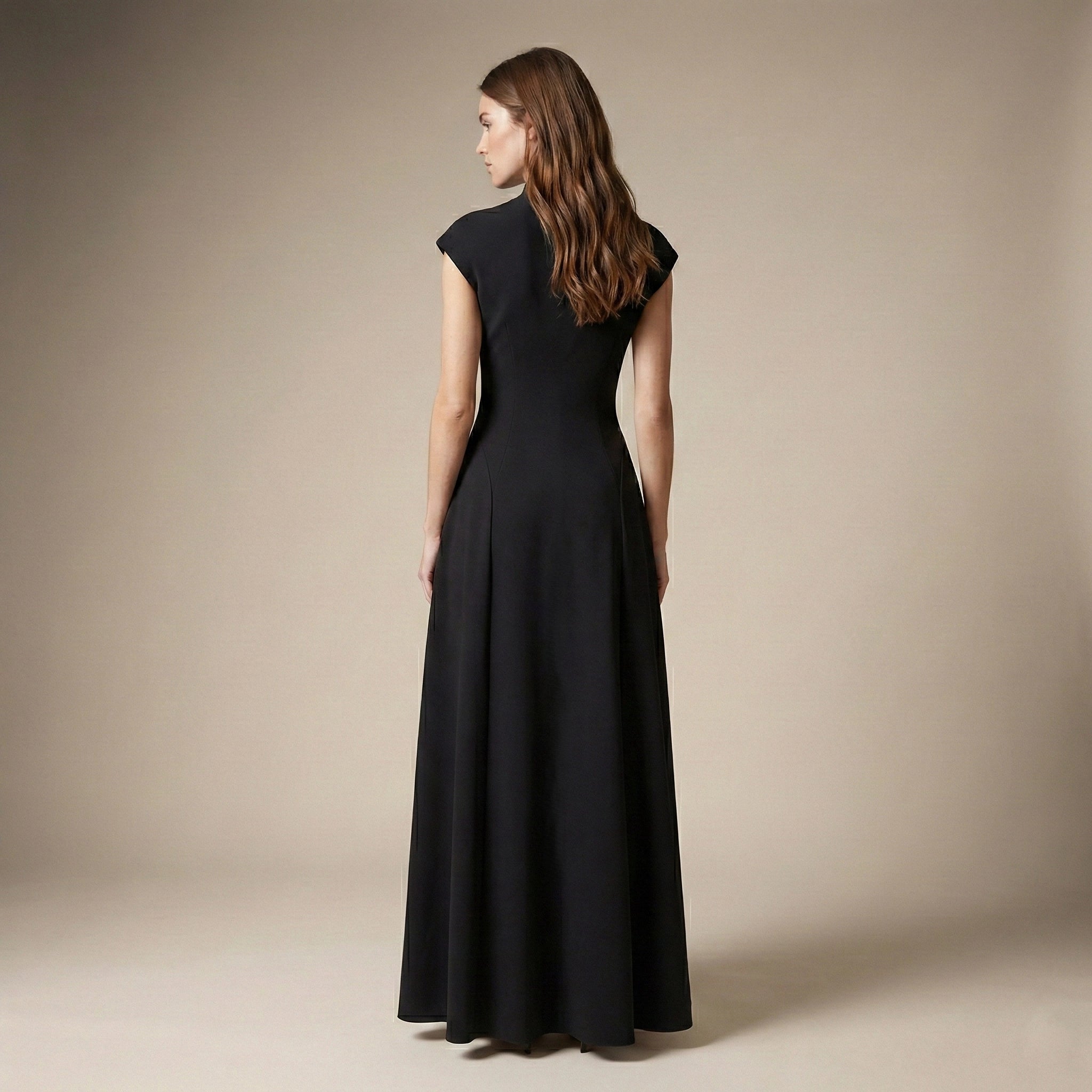 Woman wearing a black dress against a beige background