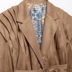 Brown coat with a colorful patterned lining on a white background