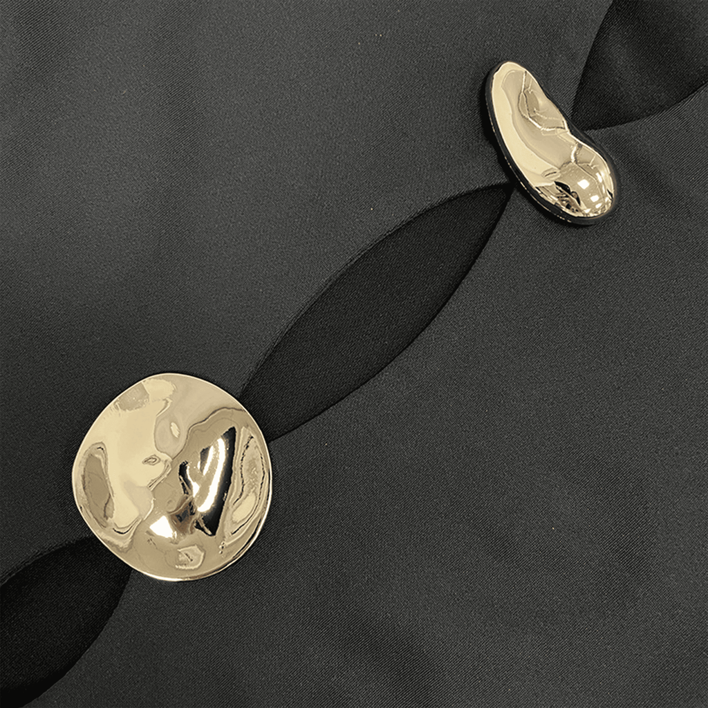 Gold earrings on a black fabric background