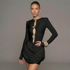 Model wearing a black dress with cut-out design on a gray background