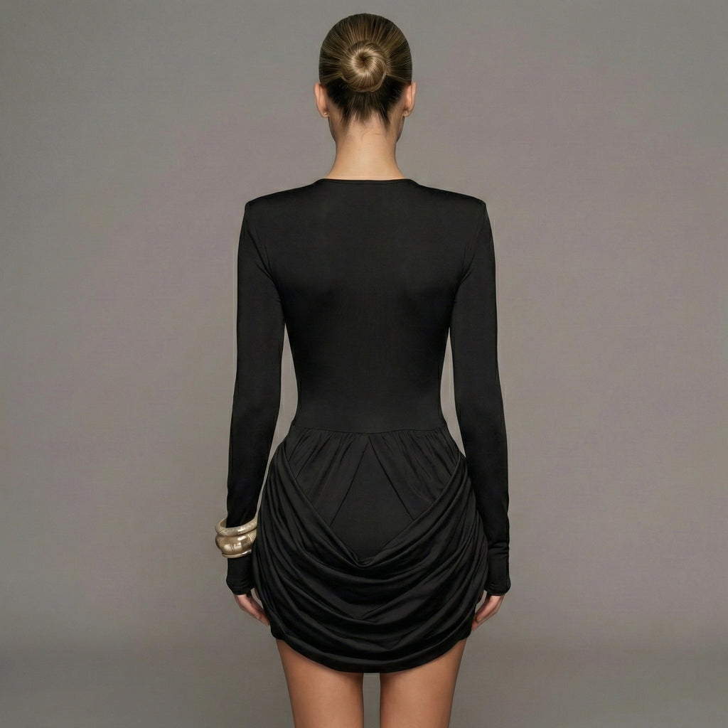 Black dress with long sleeves and a ruched skirt on a gray background