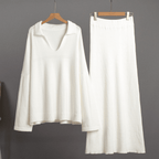 White long-sleeve top and skirt set on hangers against a gray background