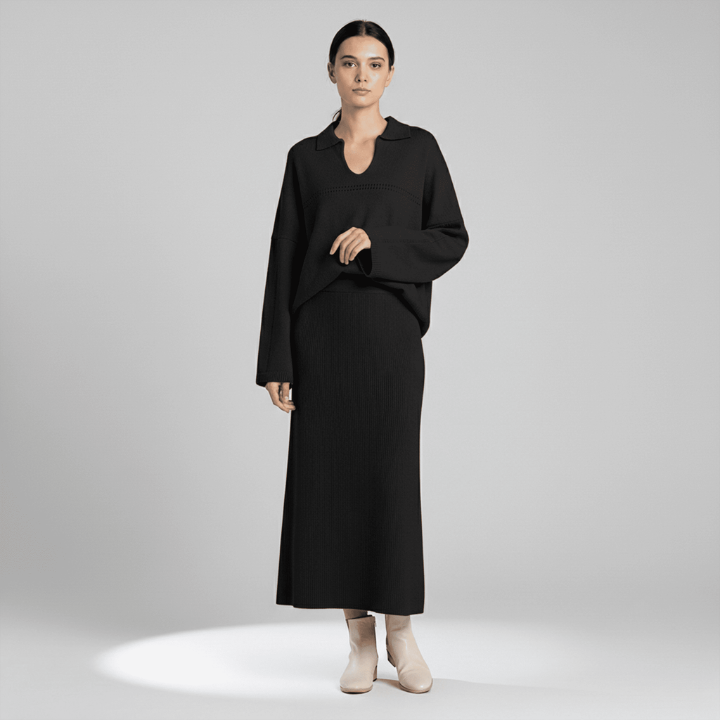 Woman wearing a black long-sleeve dress on a gray background