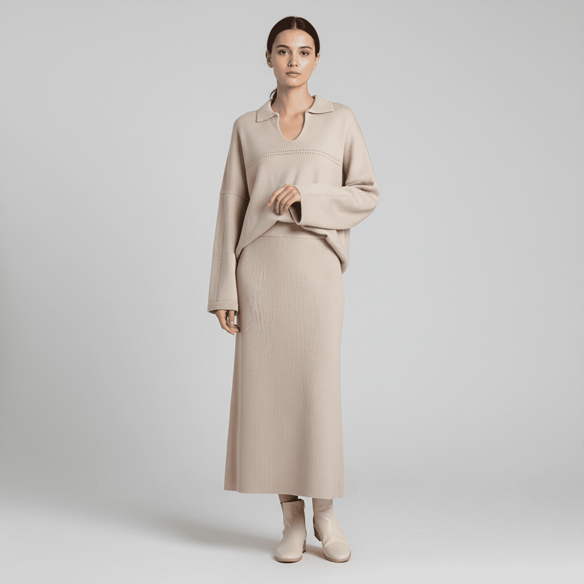 Woman wearing a beige sweater and skirt set on a plain background