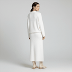 Woman wearing a white outfit on a plain background