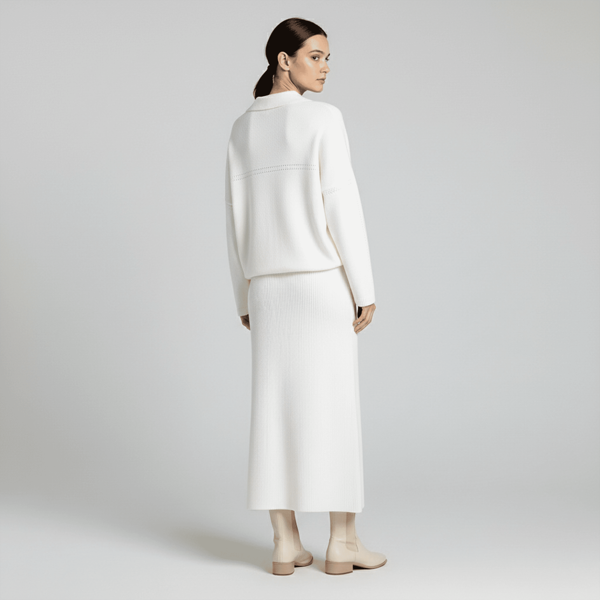 Woman wearing a white outfit on a plain background