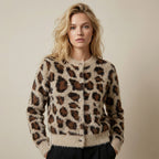 Woman wearing a leopard print cardigan against a plain background