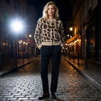 Woman wearing a leopard print sweater on a city street at night.