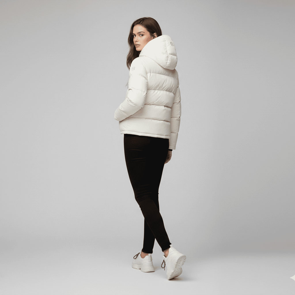 Woman wearing a white puffer jacket on a gray background