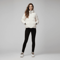 Woman wearing a white puffer jacket on a gray background