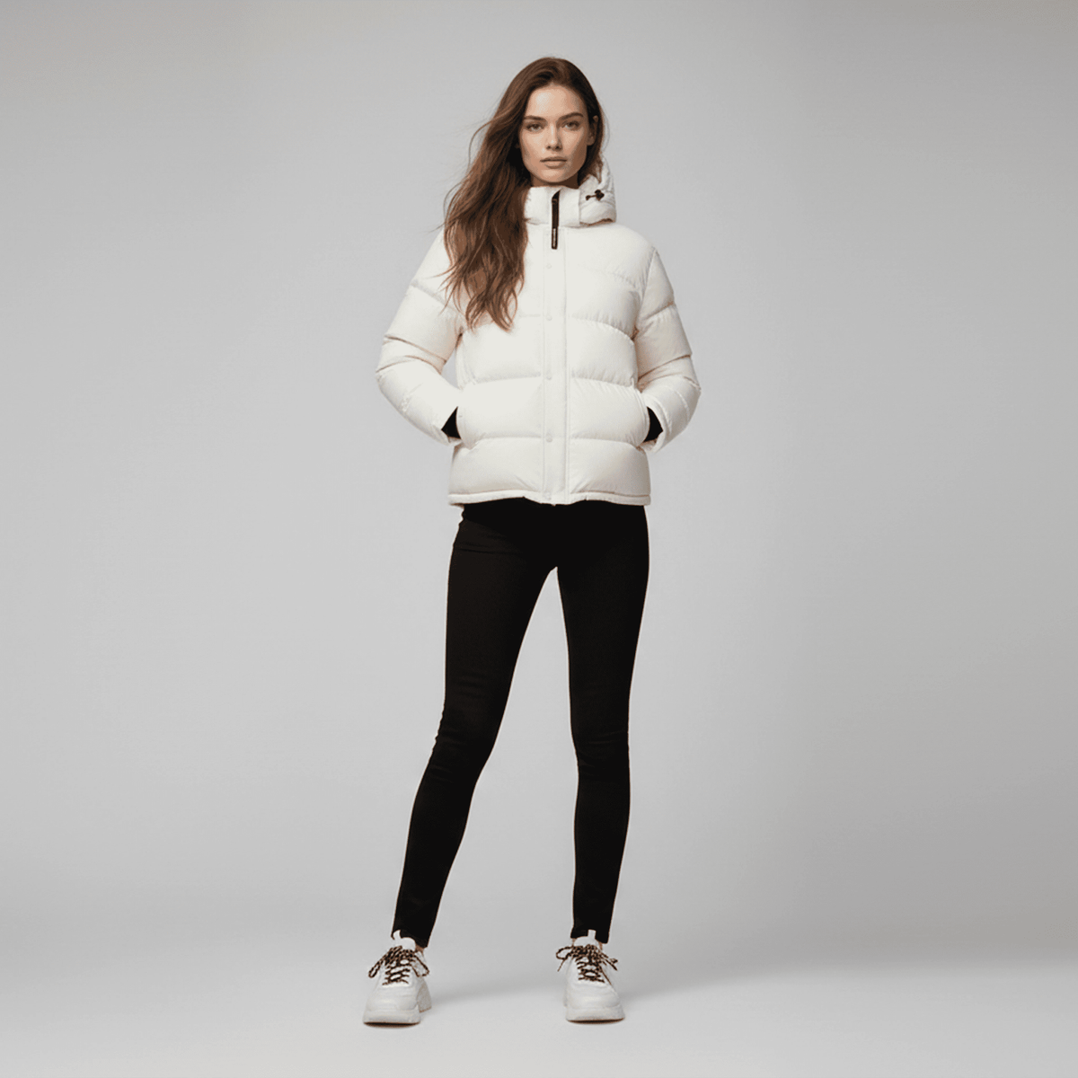 Woman wearing a white puffer jacket on a gray background