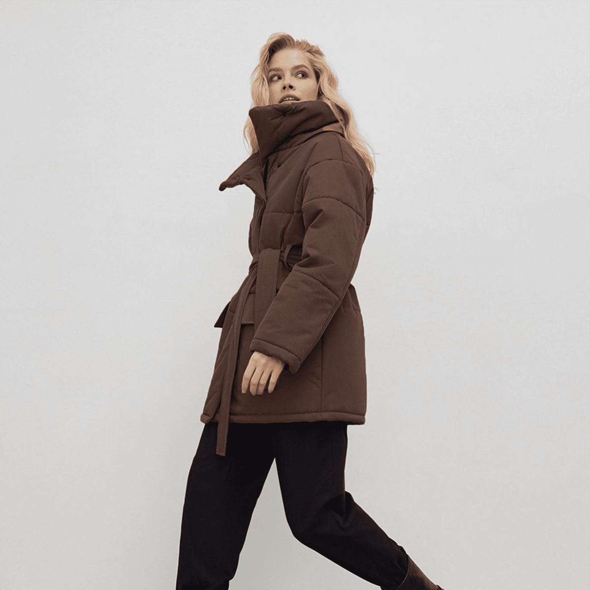 Woman wearing a brown coat on a white background