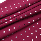 Red fabric with white polka dots and small black and gray spots