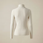 White ribbed turtleneck sweater on a beige background