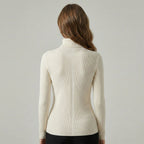 Woman wearing a cream ribbed sweater against a plain background