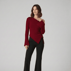 Woman wearing a red sweater with one shoulder exposed on a gray background