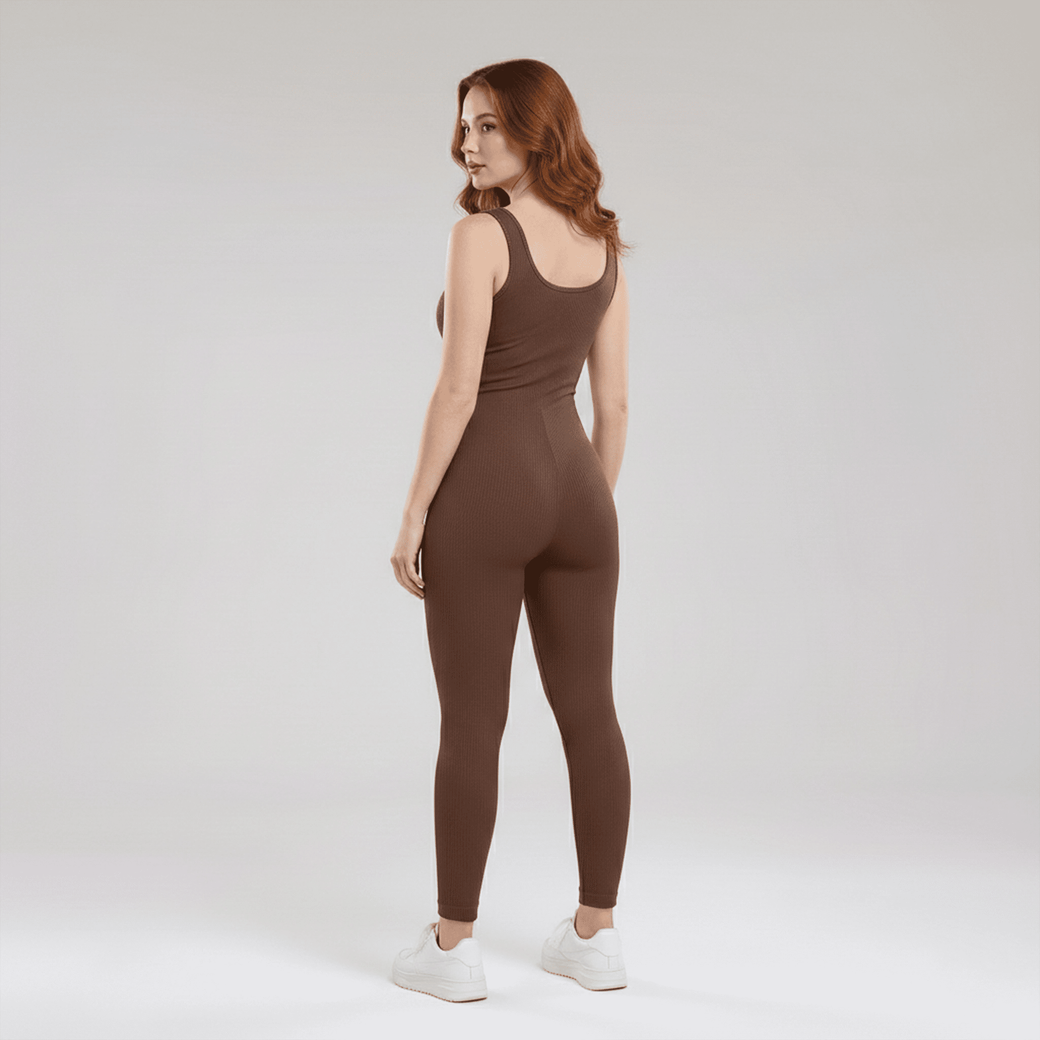 Woman wearing a brown jumpsuit on a white background