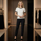 Woman wearing a white blouse with black trim and black pants in a clothing store.