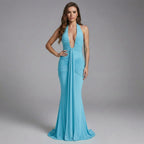 Woman wearing a blue evening gown against a gray background