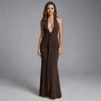 Woman wearing a brown halter neck gown on a gray background