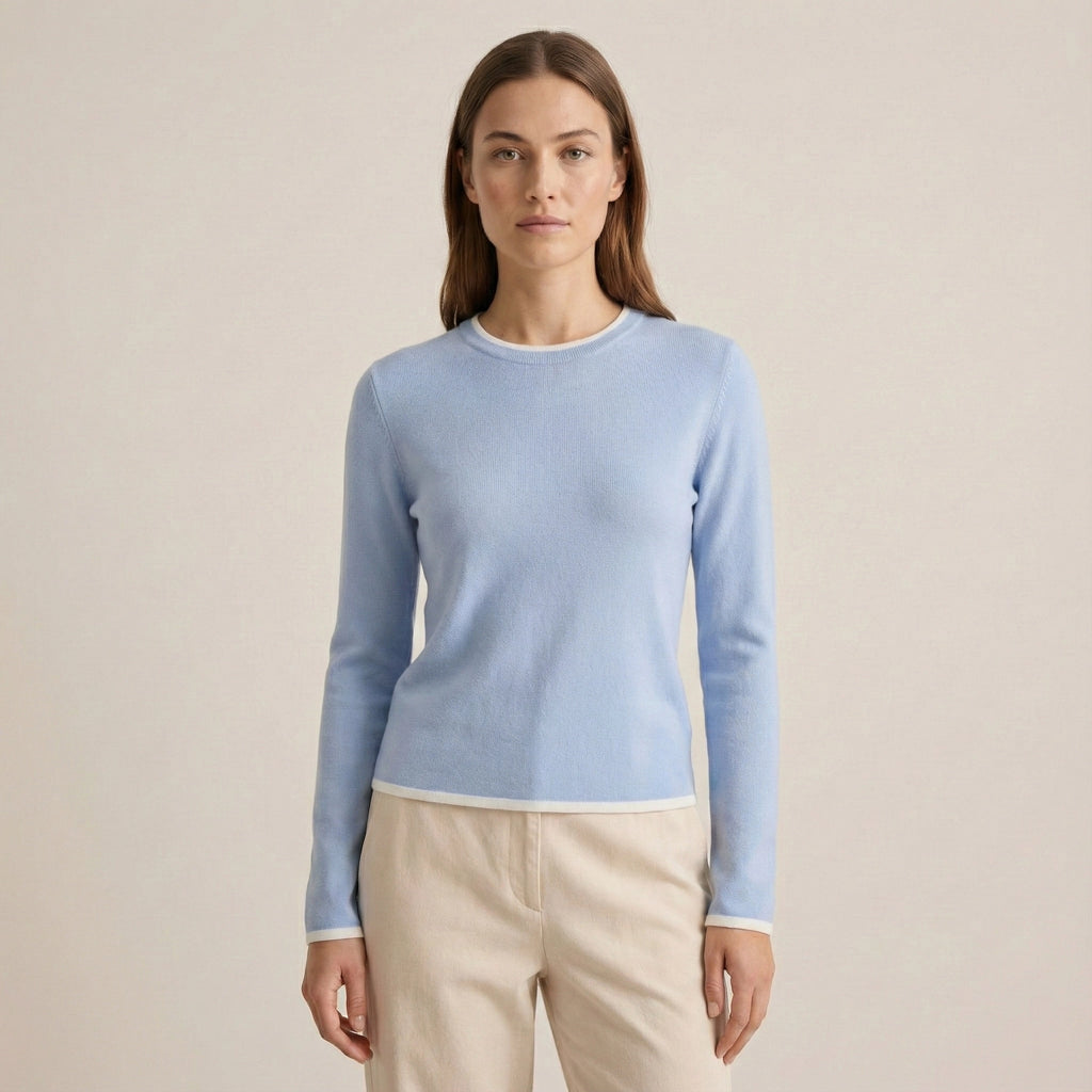 Woman wearing a light blue sweater against a beige background