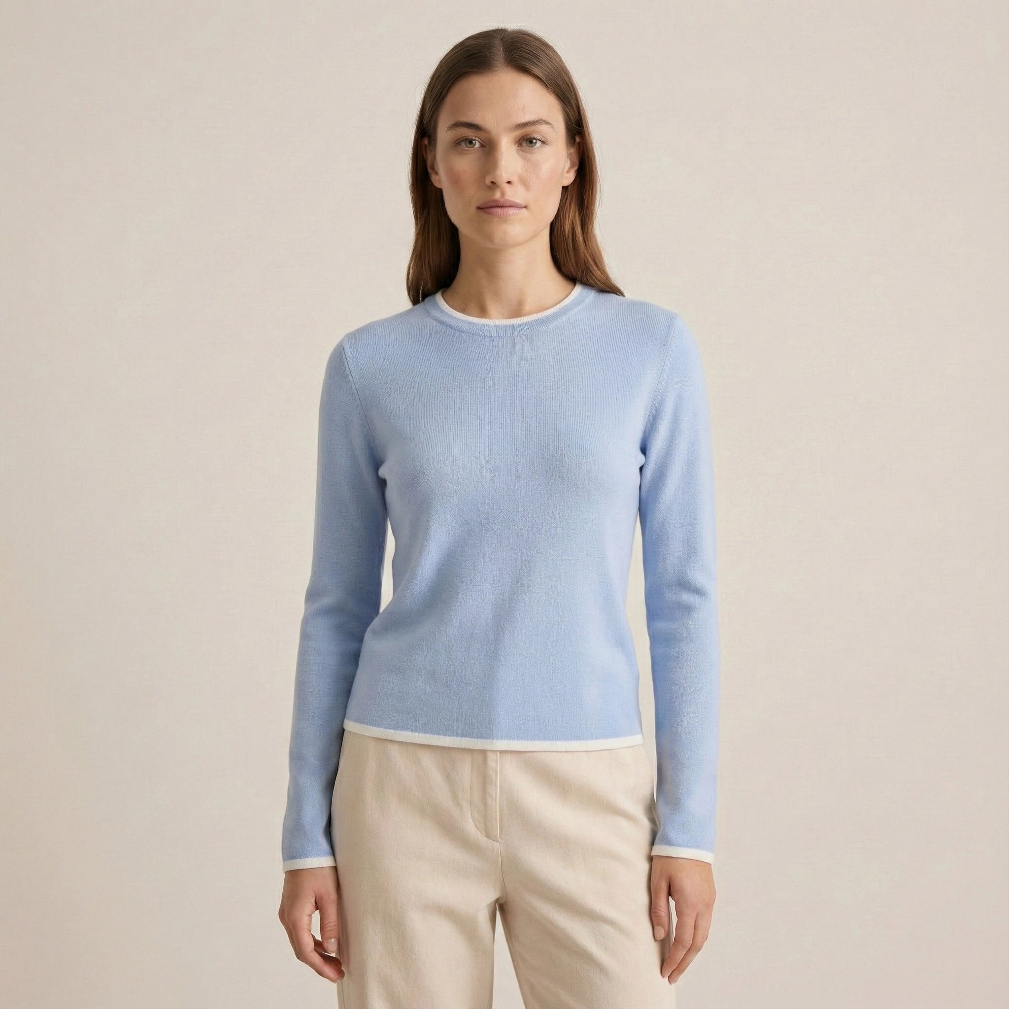 Woman wearing a light blue sweater against a beige background