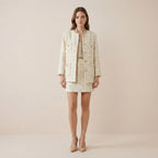 Woman wearing a beige suit on a plain background
