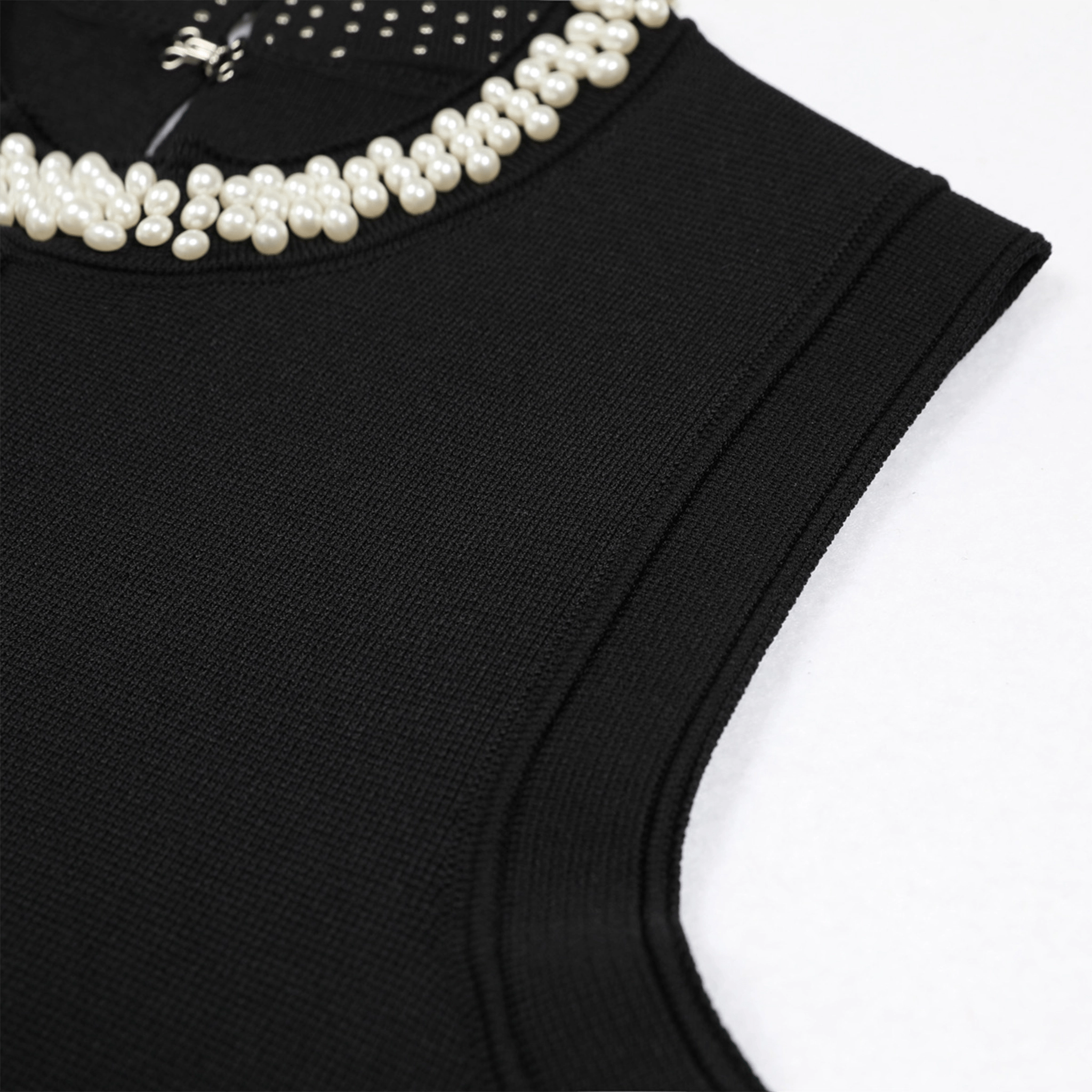 Black sleeveless top with pearl embellishments on a white background