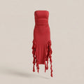 Red strapless dress with ruffled details on a beige background