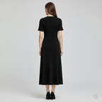 Woman wearing a black dress from behind on a light gray background