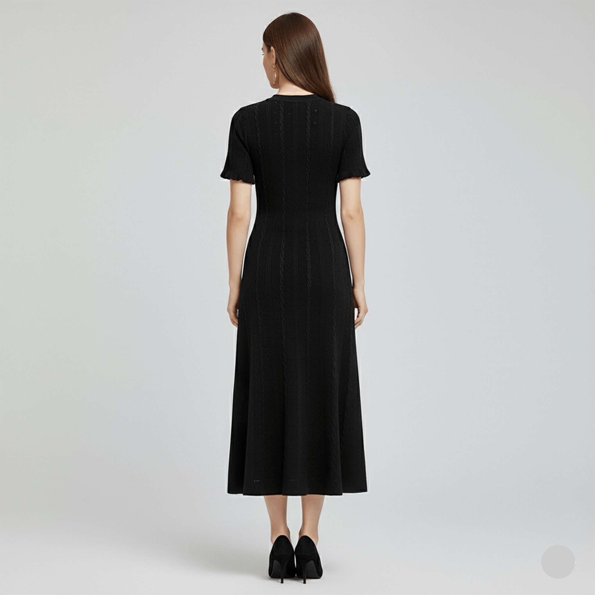 Woman wearing a black dress from behind on a light gray background