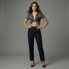 Woman wearing a sheer top and black pants against a gray background