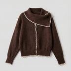 Brown sweater with white trim on a light gray background