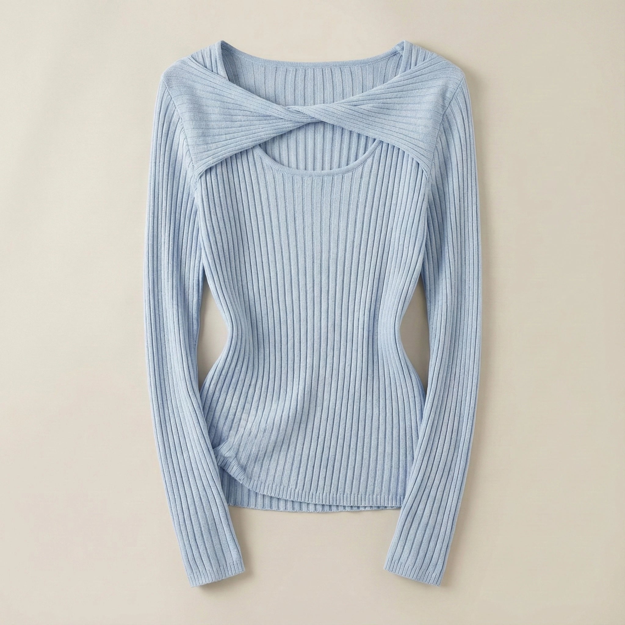 Light blue ribbed sweater with a knot detail on a beige background