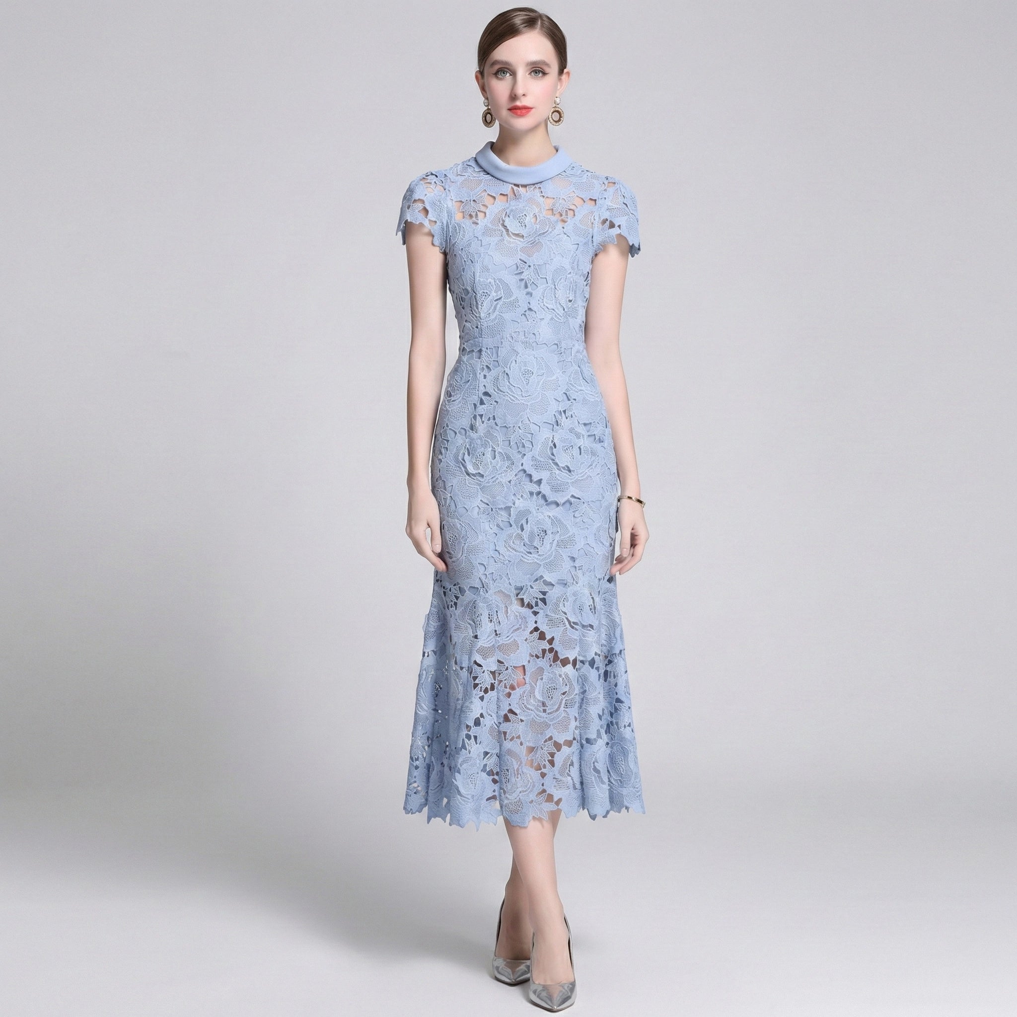 Woman wearing a light blue lace dress on a gray background