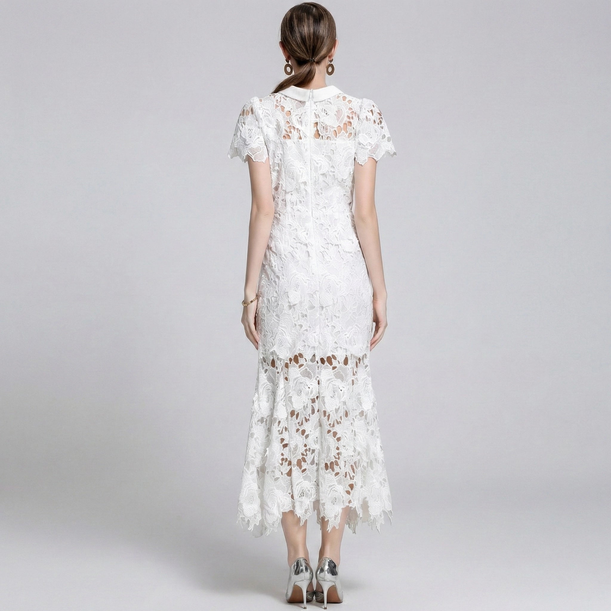 Woman wearing a white lace dress on a gray background