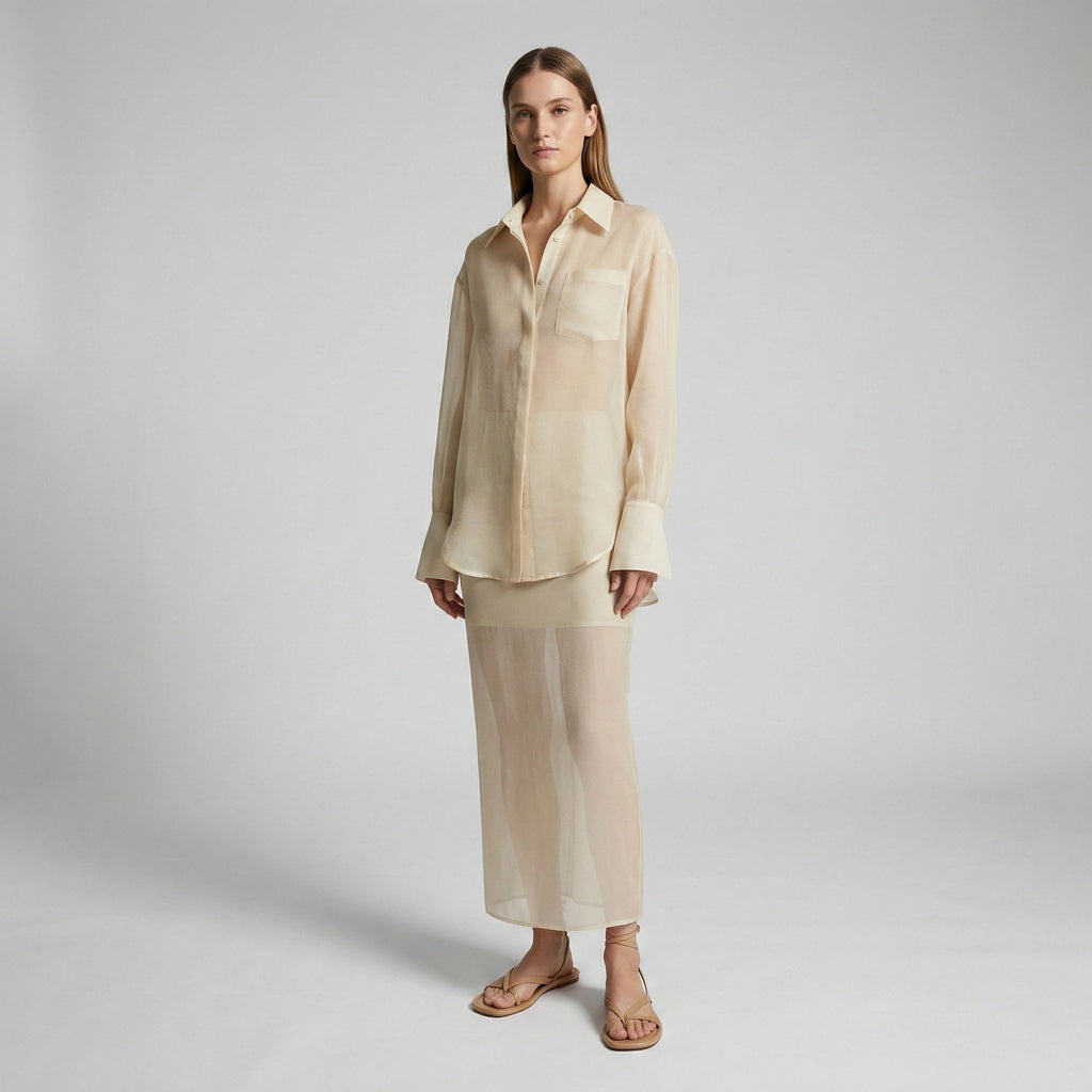 Woman wearing a beige shirt and pants on a plain background