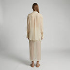 Woman wearing a beige outfit on a plain background