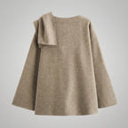 Beige sweater with a bow detail on a light gray background