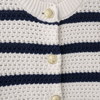 Close-up of a white and navy striped garment with gold buttons.
