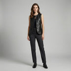 Woman wearing a black leather vest and pants on a gray background