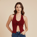 Woman wearing a red halter top with a floral detail on a beige background
