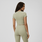 Woman wearing a green athletic outfit on a plain background